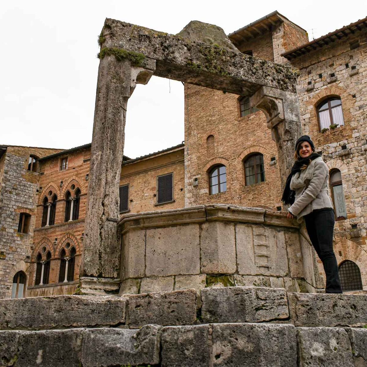 ragazza sul pozzo nella piazza principale di San Gimignano