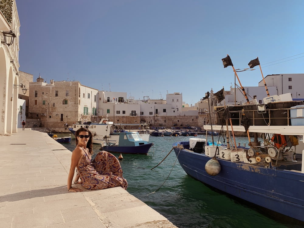 Ragazza seduta sul porticciolo del porto di Monopoli